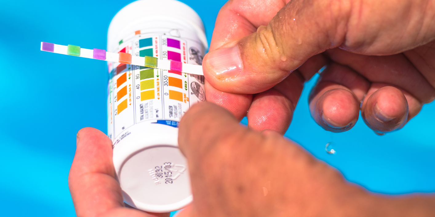 test pH piscine Un homme test le pH de sa piscine.