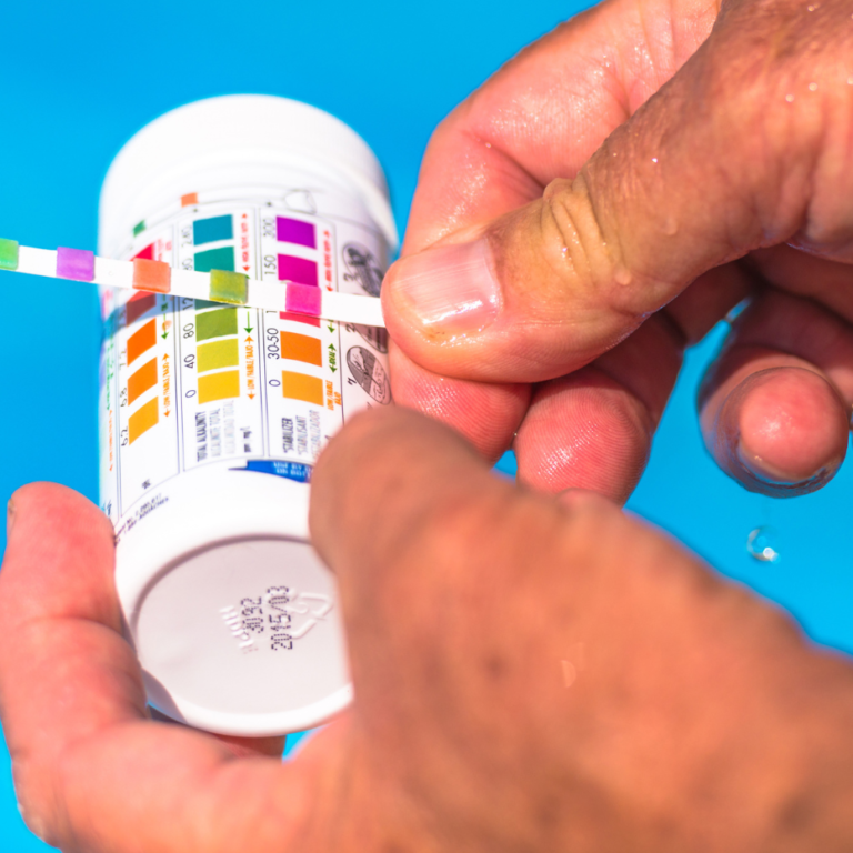 Un homme test le pH de sa piscine.