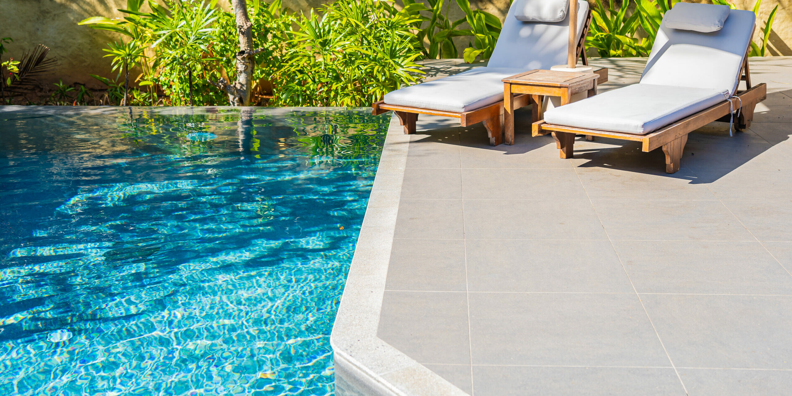 Umbrella and chair around outdoor swimming pool piscine en extérieur